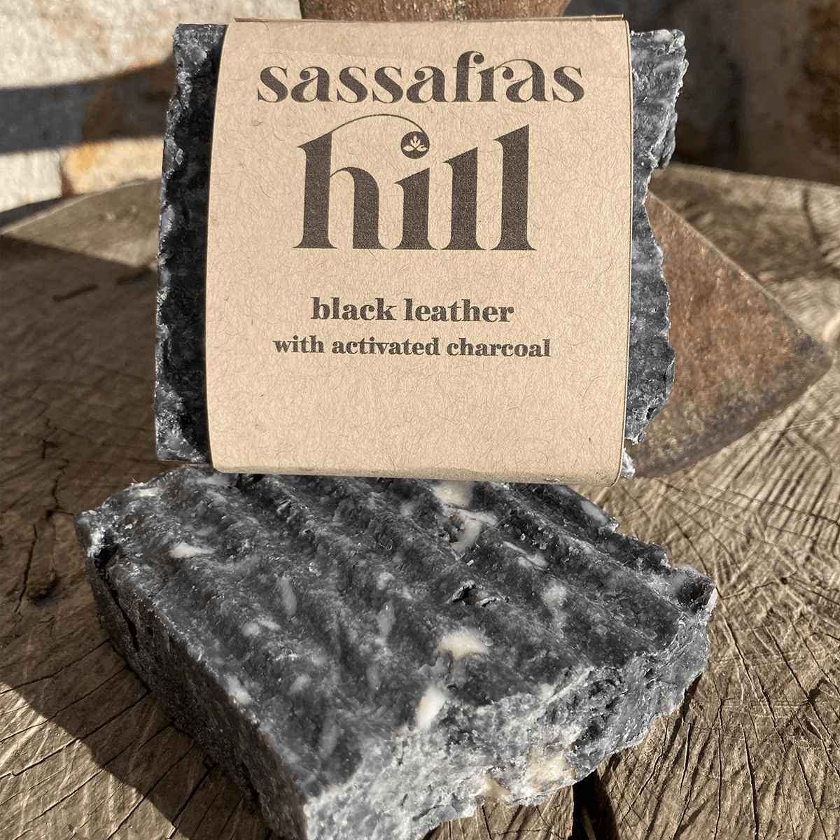 Close up of Black Leather body bar with activated charcoal and leather scent, made by Sassafras Hill