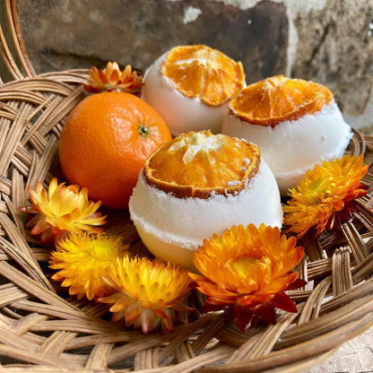 Basket of handmade bath bombs featuring orange scent and dried mandarin orange, made by Sassafras Hill