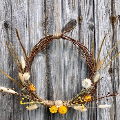 Handmade, all natural floral and grapevine wreath made by Sassafras Hill featuring neutral tones, orange and yellow flowers